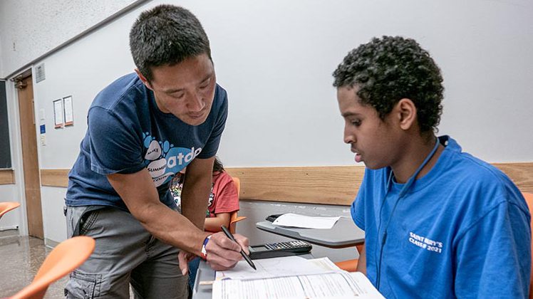 An ATDP instructor works on a math problem with a student